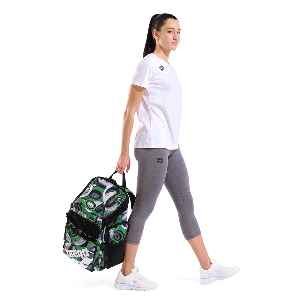 Woman holding a green and black patterned bag with a white background